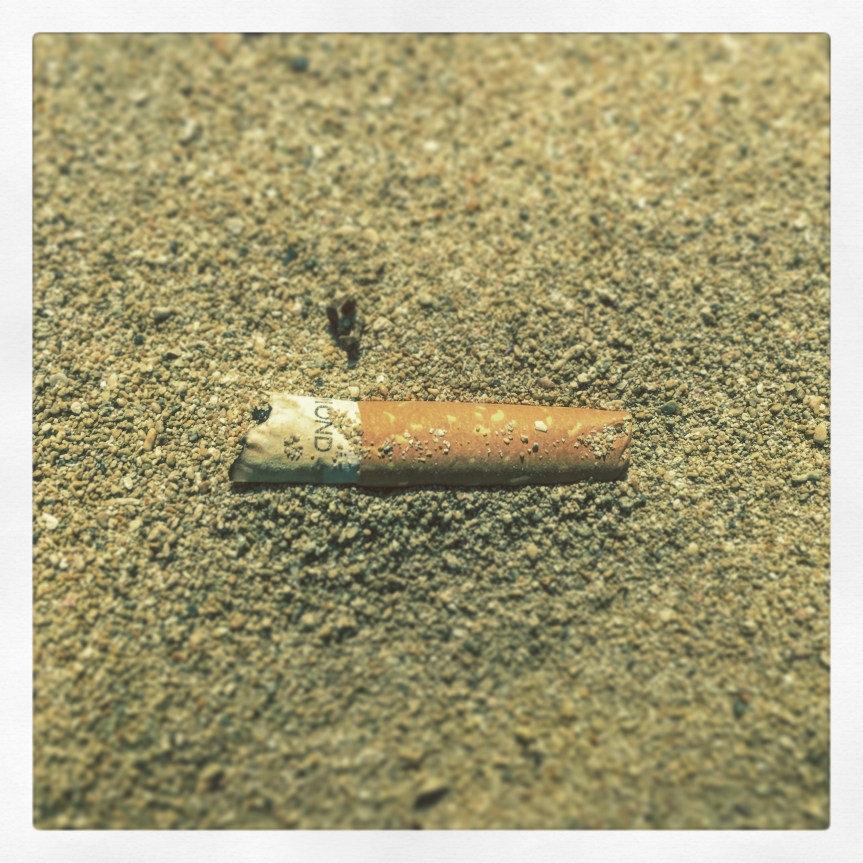 Zigarettenkippe am Sandstrand
